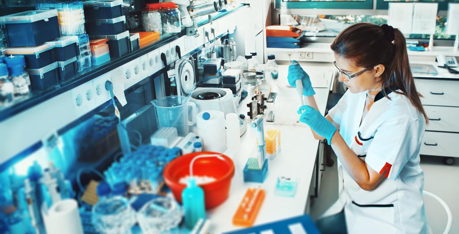 CR-freie Klebstoffe 1 Laborantin bei der Arbeit im Labor, mit verschiedenen Laborgeräten im Hintergrund.